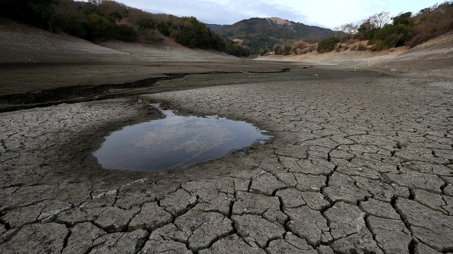 small pool of water is surrounded by dried and cracked earth that was the bottom of the Almaden Reservoir on January 28, 2014 in San Jose, California.