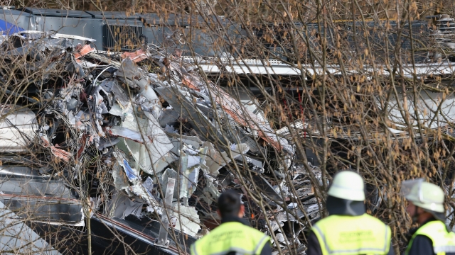 Rescue workers stand near the wreckage of two trains that collided head-on several hours before in Bavaria on February 9, 2016 near Bad Aibling, Germany.