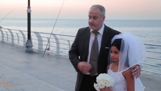 Actors pose as a groom and his child bride in Lebanon.