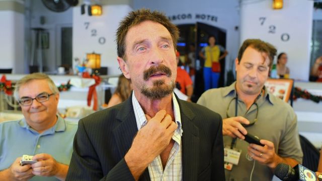 John McAfee talks to the media outside Beacon Hotel where he is staying after arriving last night from Guatemala on December 13, 2012 in Miami Beach, Florida.
