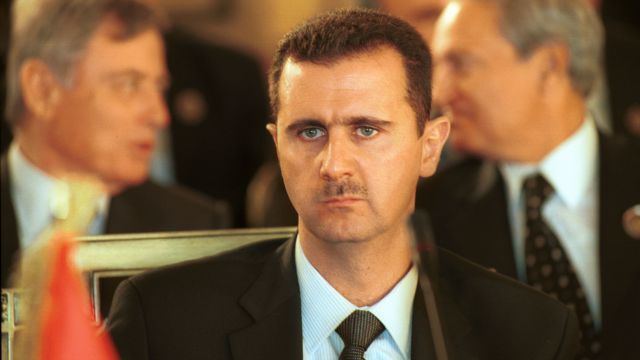 Syrian President Bashar Al Assad sits at a desk at the Arab Summit March 27, 2002 i