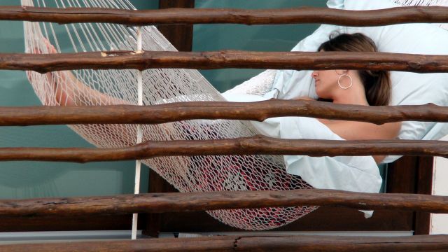 A woman sleeps in a hammock.