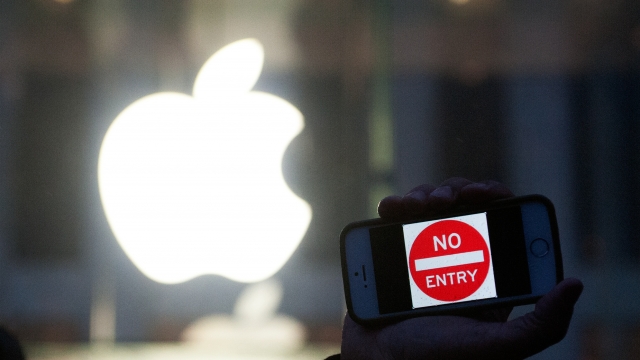 A protestor holds up an iPhone that reads, 'No Entry'