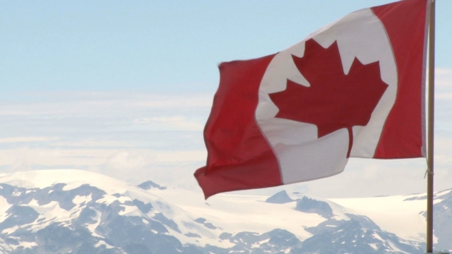 An image taken from a video of a Canadian flag blowing in the wind.