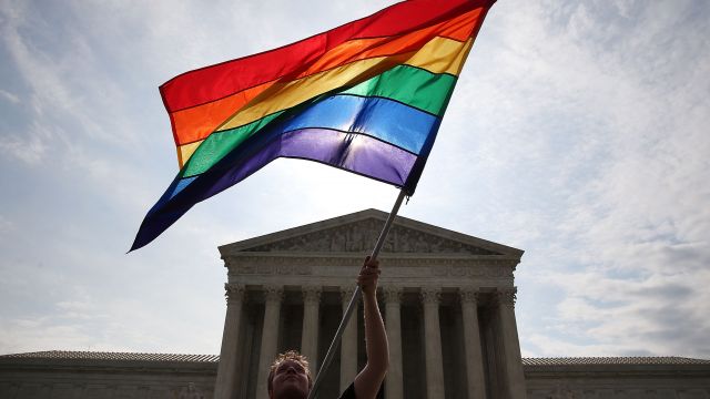A gay marriage waves a flag in front of the Supreme Court Building June 25, 2015 in Washington, DC.
