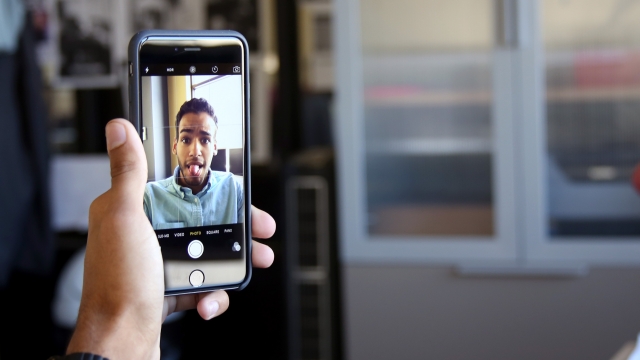 An iPhone is shown snapping a selfie.