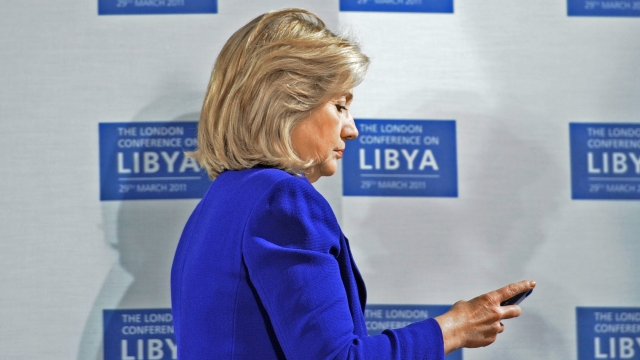 Clinton looking at a BlackBerry in 2011.