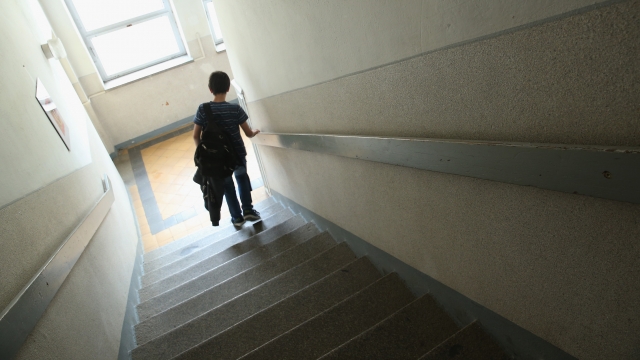 A student walks down the stairs at a middle school.