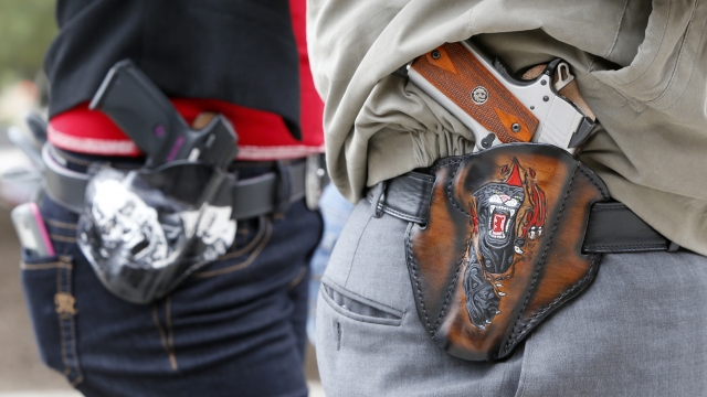 Two people carry pistols at an open carry rally at the Texas State Capitol