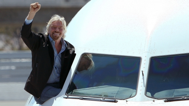 Virgin Group chairman Sir Richard Branson waves from the cockpit of an New Virgin America plane in San Francisco.