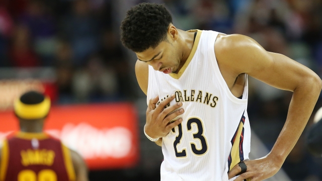 Anthony Davis of the New Orleans Pelicans walks off the court holding his chest.