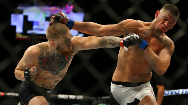 Conor McGregor punches Nate Diaz during UFC 196