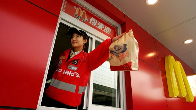 A McDonald's employee hands out food as she waits on customers at their new drive-thru facility in Beijing.