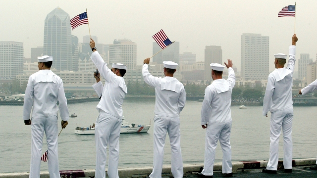 U.S. sailors wave to a passing boat