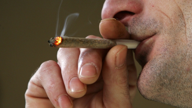 A man smokes a cigarette of marijuana
