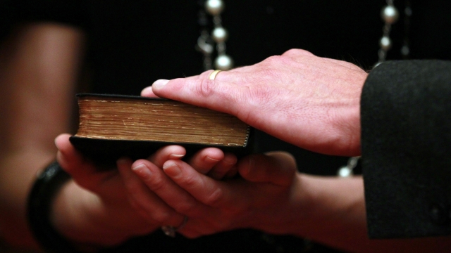 A man places his hand on a Bible.