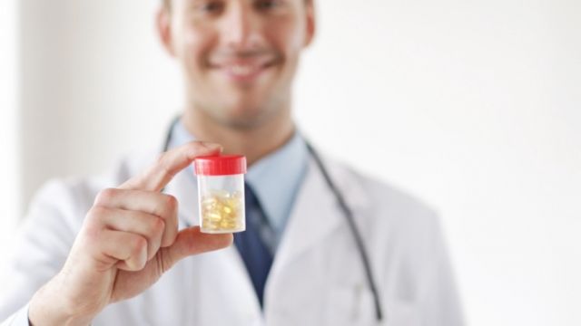 Doctor holding vitamin D3 tablets.