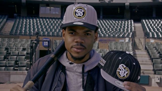 Chance the Rapper holds up newly redesigned Chicago White Sox hats.