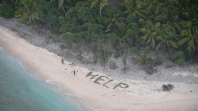 Men write "HELP" on beach of deserted Pacific island.