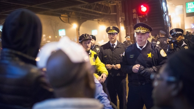 Chicago police officers talk with protesters.
