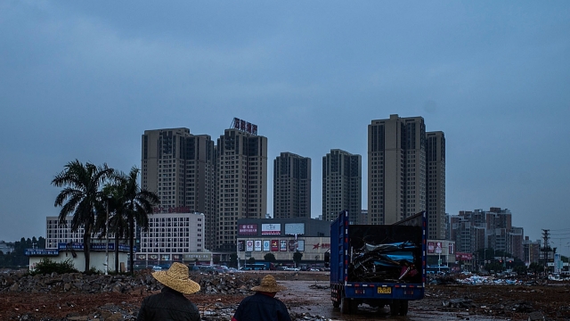 Workers walk on a path at a demolished industrial area at Houjie town on January 26, 2016 in Dongguan, China.