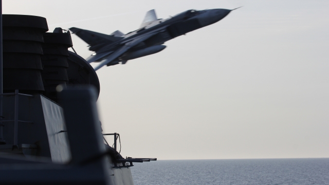 A Russian jet flies by a U.S. ship.