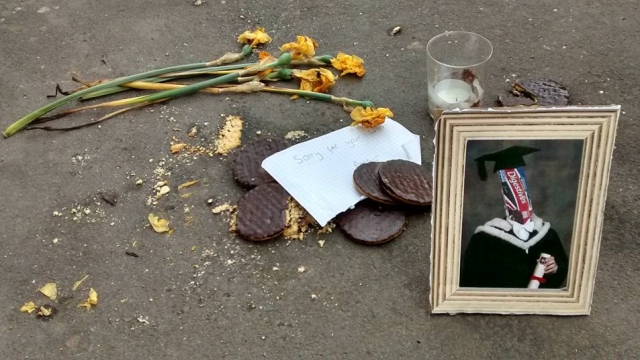 Photo of the shrine that appeared next to a bag of broken cookies on a sidewalk in Leamington Spa, England.