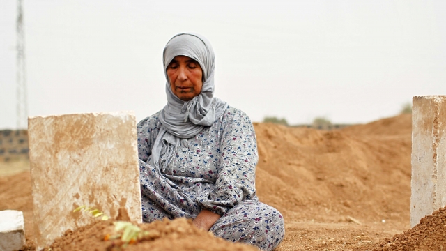 Mother by a grave of a dead Syrian fighter.