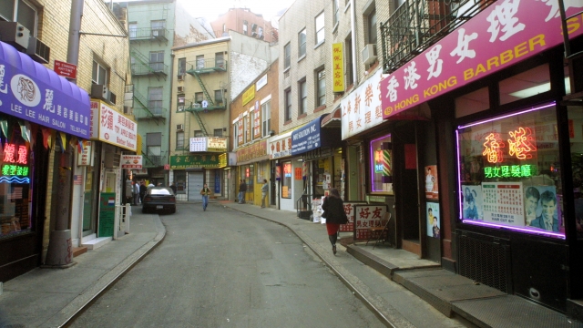 A woman walks along an empty street in New York's Chinatown.