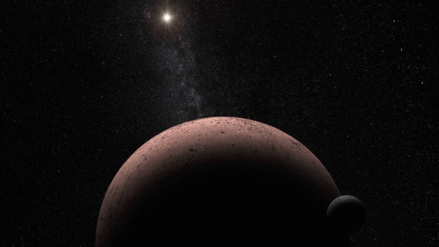 This artist's concept shows the distant dwarf planet Makemake and its newly discovered moon.