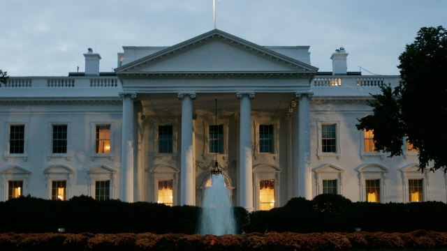 The early morning sun begins to rise behind the White House