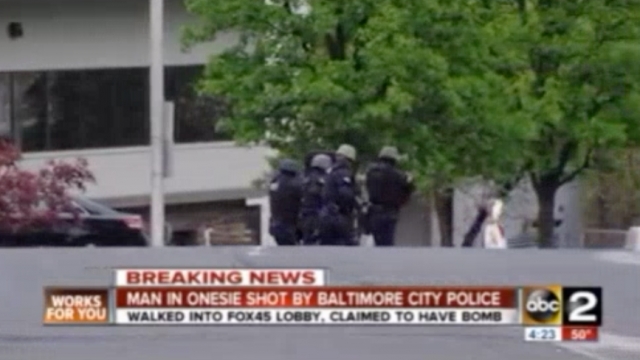 Police try to approach a suspect outside a Baltimore TV station.