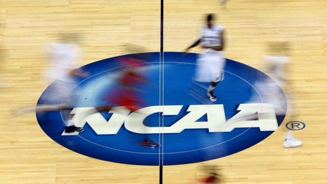 Players run by the logo at mid-court during the second round of the 2015 NCAA Men's Basketball Tournament.