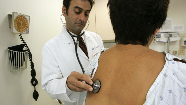 A doctor examines a patient at a women's health center.