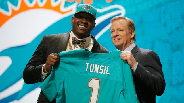 Laremy Tunsil of Ole Miss holds up a jersey with NFL Commissioner Roger Goodell after being picked #13 overall.