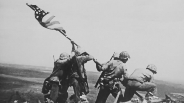 U.S. military service members raise a flag Feb. 23, 1945, on a mountain over Iwo Jima, Japan.