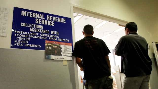 People stand at the door of a local IRS office.