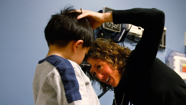Physician's assistant Erin Frazier checks a young boy at a community health center for low-income patients.