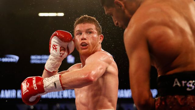 Canelo Alvarez (L) throws a left at Amir Khan during the WBC middleweight title fight.