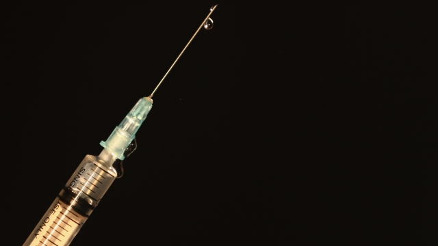 A drop of liquid is released from a syringe.