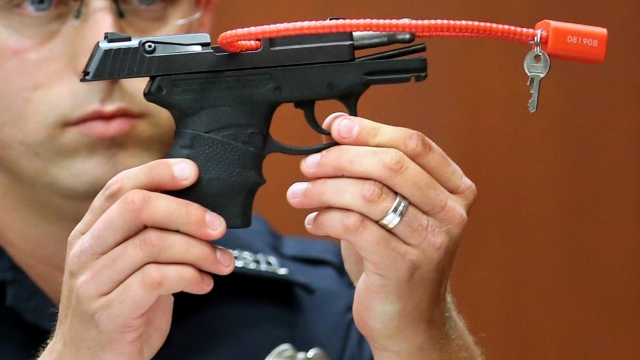 Police officer Timothy Smith holds up the gun that was used to kill Trayvon Martin.