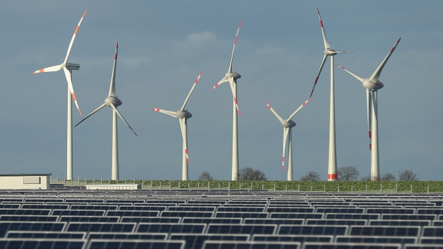 Wind turbines stand behind a solar power park near Werder, Germany.