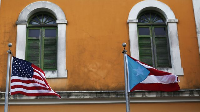 An American flag and Puerto Rican flag fly next to each other in Old San Juan, Puerto Rico.