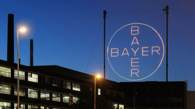 The Bayer Cross Logo shines at night.