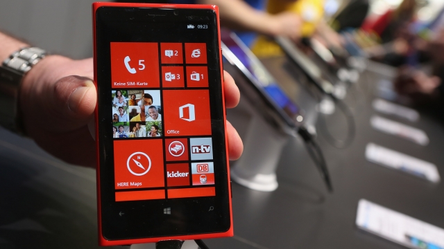 A stand host holds up a Nokia Lumia 920 Windows enabled smartphone at the 2013 CeBIT technology trade fair on March 5, 2013.