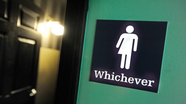 A gender neutral sign is posted outside a bathroom.