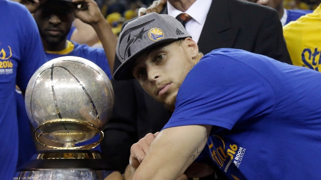 Stephen Curry #30 of the Golden State Warriors celebrates with the Western Conference Championship Trophy.