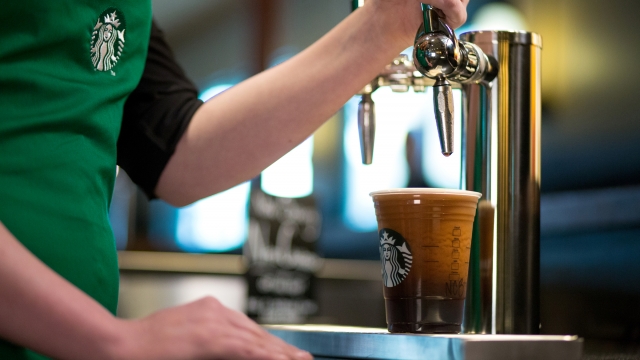 A Starbucks barista pours a Nitro Cold Brew coffee from a tap.