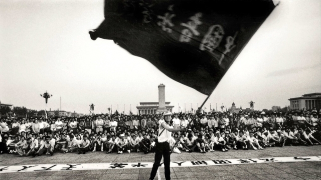 A person waves a flag in Tiananmen square