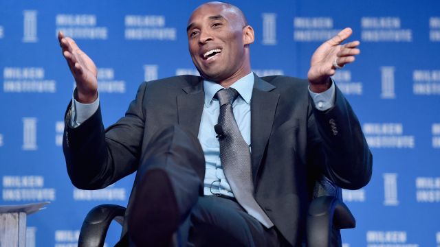 Kobe Bryant smiles as he speaks at a conference.
